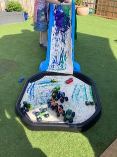 two children playing in an inflatable water slide with cars and trucks painted on it