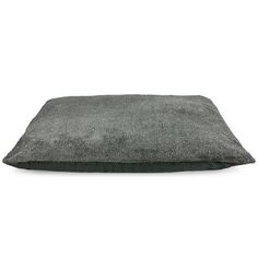 a grey dog bed with a black pillow on the bottom and white back ground behind it