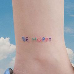 a person's foot with the word be happy written on it