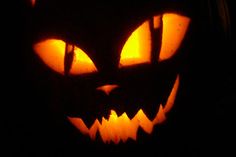 a carved pumpkin with glowing eyes in the dark