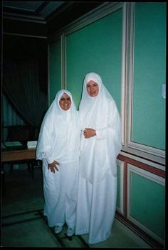 two women dressed in white standing next to each other