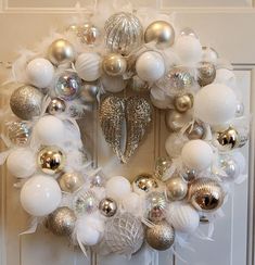 a christmas wreath with white and silver ornaments