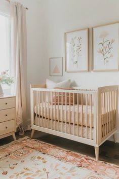 a baby's room with a crib, dresser and window