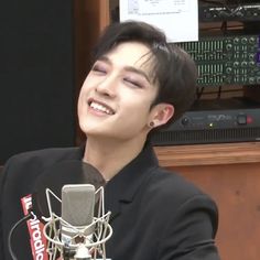 a young man sitting in front of a microphone