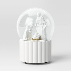 a snow globe with an image of the nativity scene in white and gold on it