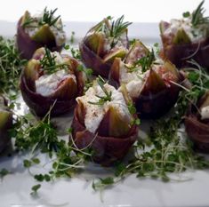 an appetizer is arranged on a plate with garnishes and herbs