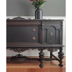 an ornate black cabinet with flowers in it