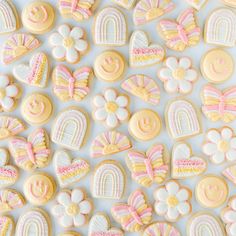 some cookies that are sitting on top of a white table with pink and yellow icing