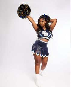 a woman in a cheerleader outfit is holding a pom - pom and posing for the camera