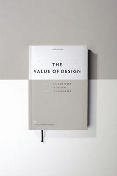 the value of design book on a white and gray wall with a black pen sticking out of it