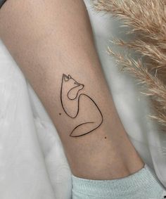 a woman's arm with a small black line drawing of a cat on it