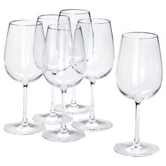 six empty wine glasses lined up in a row