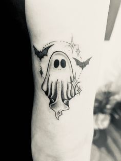 a black and white photo of a tattoo with a ghost on it's arm