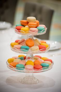 three tiered glass plate with colorful macaroons on it