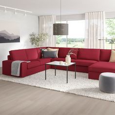 a living room with red couches and white rugs on the floor in front of a large window