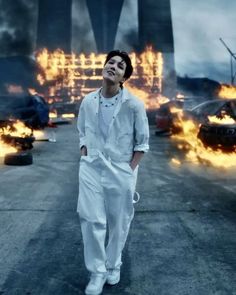 a man standing in front of burning cars