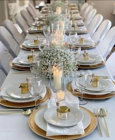 the table is set with white and gold plates