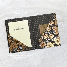 a close up of a folded card with flowers on it and a note attached to the back