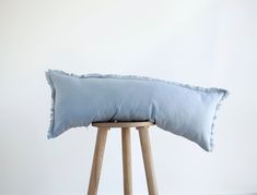 a blue pillow sitting on top of a wooden stool