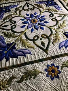 an intricately designed table top with blue flowers on it