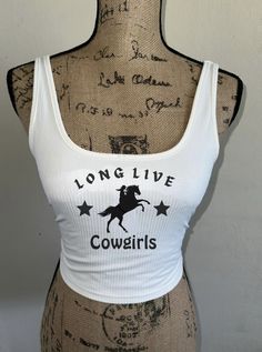 "\"Long Live Cowgirls\" tank top with a cowgirl on a horse silhouette and stars! Comes in white, tan/beige, or dusty blue! Perfect for summer time, bathing suit cover up! Any occasion! Breathable material. Western wear, country concert, wash on cold and delicate setting for longevity! Visit my page for similar styles!  Feel free to message me with any questions and I'm sure we can work something out! Ex. Can you do the letters in red instead?" Western Style Graphic Print Summer Top, Western Style Graphic Print Tops For Summer, Western Tops With Graphic Print For Summer, White Tops For Summer Rodeo, Graphic Print Tops For Summer Country Events, White Summer Tops For Rodeo, Summer Graphic Print Tops For Country Events, White Top For Rodeo Summer Events, Graphic Print Tops For Country Events In Summer