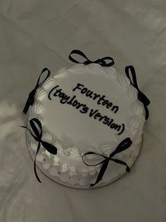 a white cake with black ribbon and name written on it