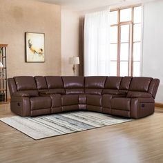 a living room with a large brown leather sectional sofa and rug on the wooden floor