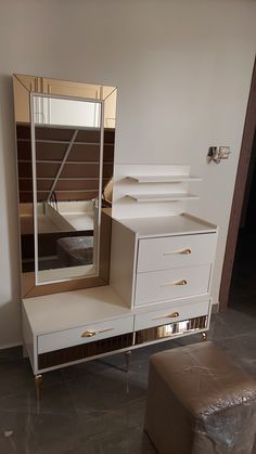 a white dresser sitting next to a mirror on top of a table