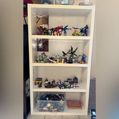 a white book shelf filled with legos and toys