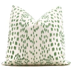 a green and white pillow with spots on it's side, in front of a white background