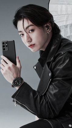 a woman in black jacket holding up a cell phone