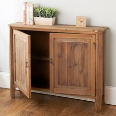 a small wooden cabinet with two doors on the front and one door open to reveal a potted plant