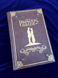 the princess bride book is laying on a blue cloth