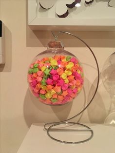 a glass ornament filled with colorful confetti on top of a table