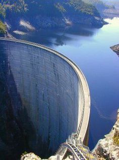 a man standing on the side of a large dam