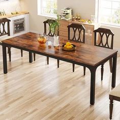 a dining room table with chairs and fruit on the plate next to it in front of an oven