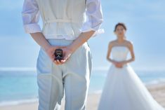 the bride and groom are standing on the beach with their cell phones in their hands