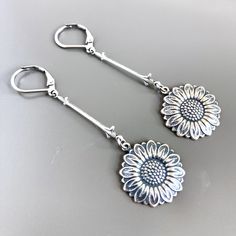 "Silver Sunflower Earrings - Antiqued Silver plated Sunflowers dangle from Antiqued Silver plated Fleur de lis Connectors. Sunflowers are approximately 15 mm (size of US dime) Surgical Steel Earwires Earrings measure just under 2.5\" from top of earwire to bottom" Vintage Flower Charm Dangle Earrings, Vintage Dangle Earrings With Flower Charm, Vintage Drop Earrings With Flower Charm, Adjustable Nickel-free Flower Earrings For Everyday, Silver Flower Earrings With Lever Back Ear Wires, Nickel-free Drop Flower Earrings For Everyday Wear, Everyday Dangle Earrings With Flower Charm, Everyday Nickel-free Dangle Flower Earrings, Adjustable Flower Shaped Earrings For Everyday