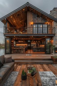 an outdoor living area with couches and tables in front of a large wooden house