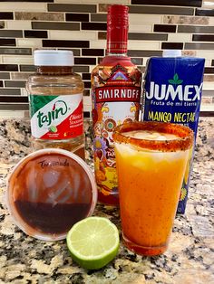 the ingredients to make an alcoholic drink are displayed on a counter top, including orange juice and lime