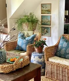 a living room with wicker furniture and plants on the table in front of it