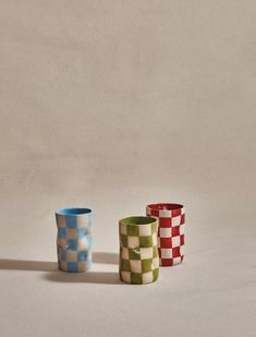 three different colored cups sitting next to each other