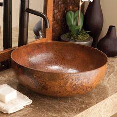 a brown bowl sitting on top of a counter next to a mirror and soap dispenser