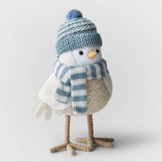 a knitted bird wearing a blue and white striped hat, scarf and mittens