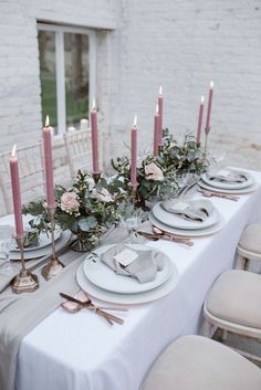 the table is set with candles, plates and napkins for an elegant wedding reception