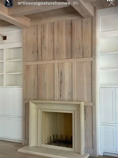 an empty living room with wood paneling on the walls and a fire place in the center