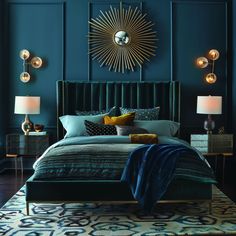 a bedroom with blue walls and gold accents on the headboard, bedding, and nightstands