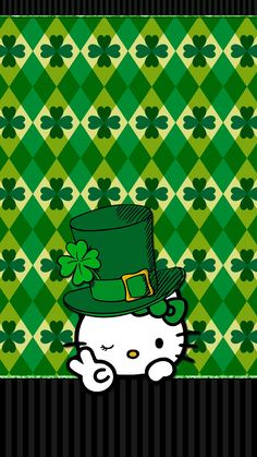 a hello kitty with a green hat and clovers on it's head, standing in front of a checkered background