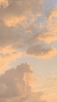 the airplane is flying high in the sky with clouds behind it and one plane on the ground