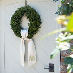 a green wreath hanging on the side of a door